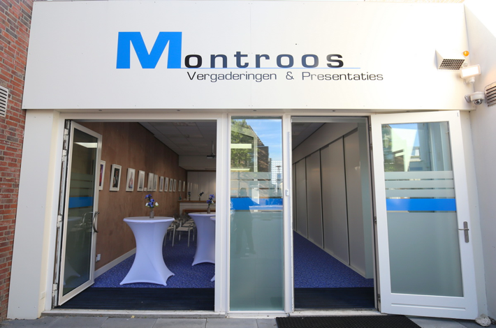 De entree van Montroos Vergaderingen & Presentaties bestaat uit de kleuren wit, blauw en zwart. Deze kleuren komen overeen met die van het naastliggende gebouw: Montroos Administratie- en Advieskantoor.